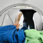 mand tager toerre haandklaeder ud af toerretumbler 150x150